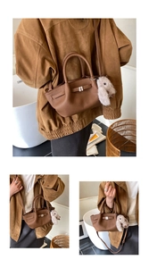 Detailansicht braune Wildleder-Unterachseltasche mit Metallschnalle und Hasenanhänger