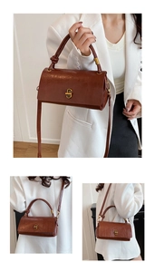 Detailed view of brown leather handbag with knot handle and golden lock clasp