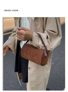 Brown suede bolster bag styled with a beige trench coat for a trendy street look