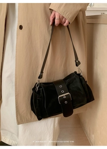 Détail du sac rétro noir avec boucle à œillets métalliques et texture en cuir souple