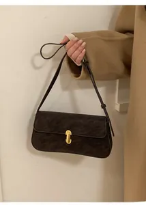 Détail d'un sac à main en cuir PU texturé vintage avec boucle dorée et bandoulière réglable