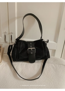 Détail d'un sac bandoulière vintage en daim noir avec boucle argentée et poignée large