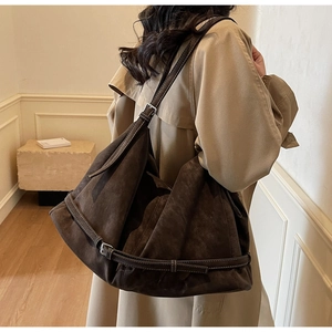 Detailansicht der dunkelbraunen Wildleder-Hobo-Tasche mit verstellbaren Silberschnallen