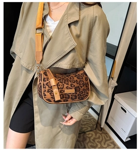 Detail of leopard print crossbody Boston bag with adjustable wide orange strap on model