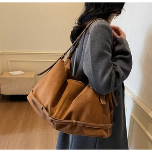 Nahaufnahme der Textur der karamellfarbenen Wildledertasche und des Lederriemens
