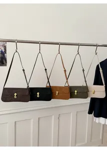 Détail de sacs sous le bras en suédine en cinq couleurs avec boucles métalliques