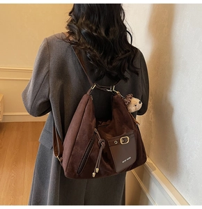 Détail du sac cabas en daim café avec logo MCGK PARIS et breloque ours en peluche