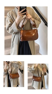 Detail of dark brown leather saddle bag with wide patterned strap and tassel charm