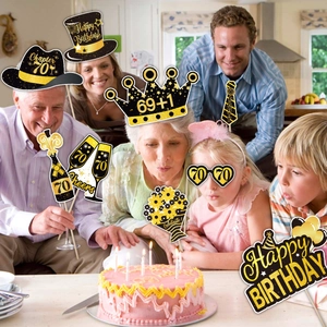 Family using 70th birthday party photo booth props in elegant black and gold design