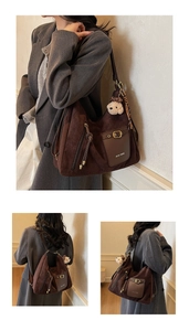 Détail d'un grand sac cabas en daim marron avec poche en cuir et breloque petit chien