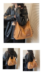 Détail du sac fourre-tout en daim marron avec poche à boucle et pendentif chiot