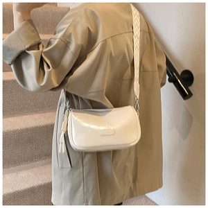 Detail of white glossy leather Boston bag with a patterned wide webbing shoulder strap