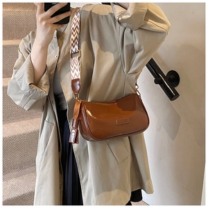Brown Boston bag with vintage wave strap and leather tassel detail on model
