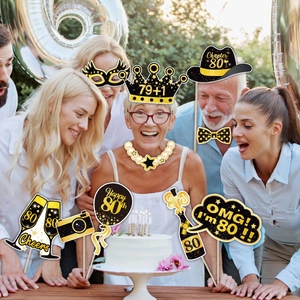 Black and gold 80th birthday photo booth props including crowns, bow ties and champagne