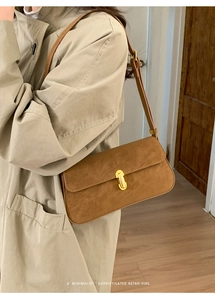 Détail du sac bandoulière rétro en daim marron avec un fermoir en métal doré chic
