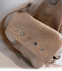 Detailed macro view of apricot leather bag with silver studs and fine stitching texture