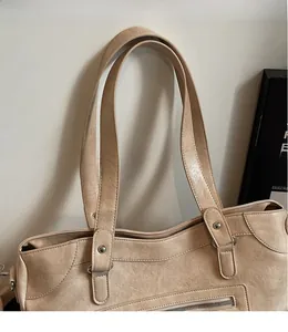 Detail view of reinforced long shoulder straps and smooth leather texture on tote bag