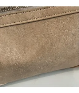 Detail of beige faux leather with vintage texture and white stitching on tote bag