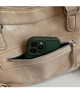 Detail of exterior zipper pocket on beige pebbled leather tote showing phone storage