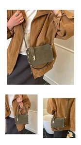 Detail of dark olive green leather crossbody bag with vintage golden metal buckle