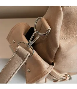 Detail of silver swivel hook and precision stitching on the beige tote bag handle