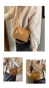 Close-up of vintage brown leather handbag with gold rivets and lock details
