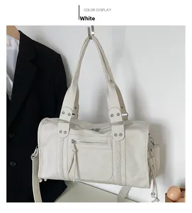 Detail of white faux leather Boston travel bag with woven texture and silver studs