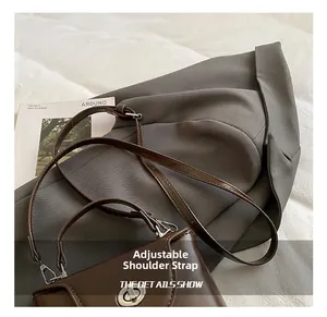 Détails de la bandoulière réglable en cuir et du fermoir rotatif en métal argenté du sac