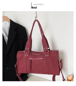Detail of burgundy travel bag featuring woven straps and functional front zipper pocket