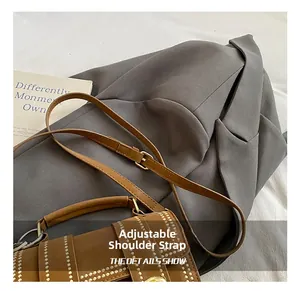 Nahaufnahme der braunen Boston-Tasche mit goldenen Nieten und verstellbarem Riemen