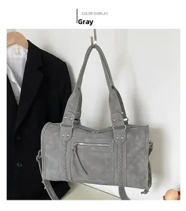 Detailed view of gray travel handbag with matte finish and woven decorative straps