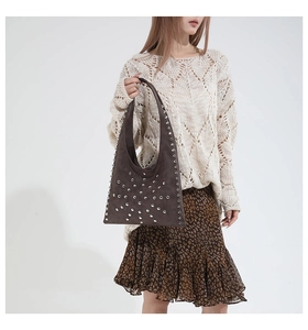 Détail du sac bandoulière en daim marron foncé avec rivets argentés et style rétro