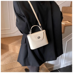 Détail du sac boîte en similicuir blanc crème avec fermoir rotatif argenté et bandoulière