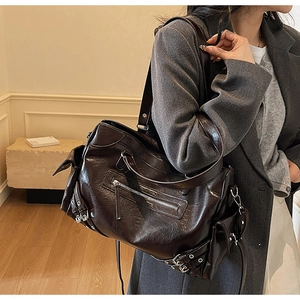 Detail shot of the vintage dark brown leather tote bag showing multiple silver zippers