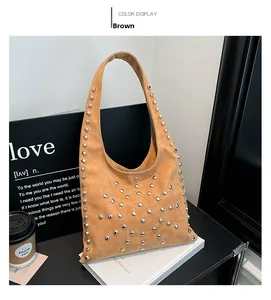 Detail view of brown suede shoulder bag with silver rivet studs in V-shape pattern