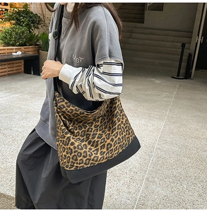 Detailed macro view of leopard print canvas cross-body bag with adjustable nylon strap