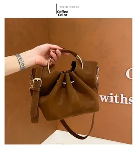 Detail of coffee brown tote with golden round metal handle and drawstring closure