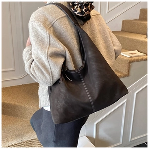 Close-up of vintage brown oversized tote bag featuring contrast white stitching details