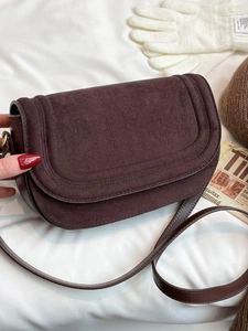 Dark brown suede and leather saddle bag with flap closure and adjustable shoulder strap