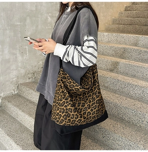 On-body shot of large leopard print canvas tote bag with black strap and reinforced base