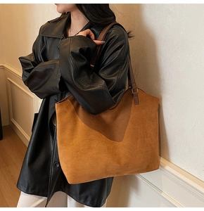 Close-up of brown suede tote bag texture with slim leather straps on shoulder