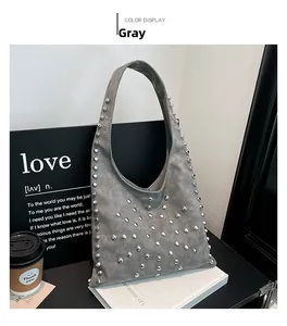 Detailed close-up of grey frosted leather shoulder bag with silver metallic rivets