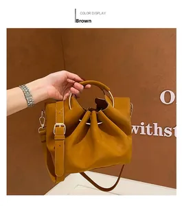 Close-up of brown soft leather tote bag featuring drawstring detail and gold ring handles
