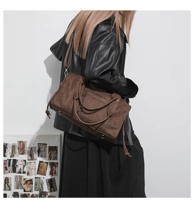 Detail of deep brown retro travel bag with bohemian woven side straps and matte finish