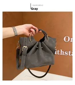 Detail of grey slouchy tote bag with gold metal ring handles and soft matte texture