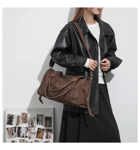 Deep brown retro travel bag with textured leather and adjustable wide shoulder strap