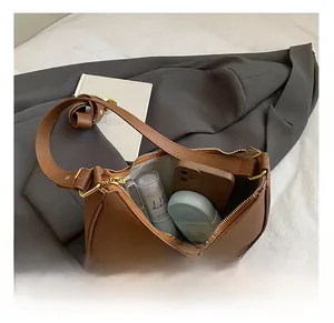 Macro shot of brown dumpling bag interior showing large capacity for phone and cosmetics