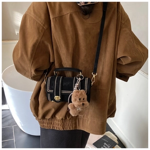Dettaglio borsa Boston in camoscio nero con borchie dorate e ciondolo orsetto di peluche
