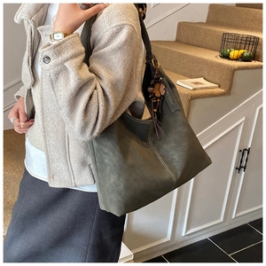 Detail of olive green matte tote bag with contrast white stitching and leaf pendant