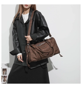 Detail view of brown large capacity travel bag with woven texture and adjustable strap